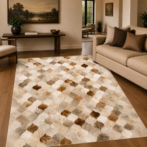 Könnte beinhalten: Ein rechteckiger Teppich mit einem sich wiederholenden Vierpassmuster in Braun-, Beige-, Creme- und Grautönen. Der Teppich liegt flach auf einem Holzboden und bedeckt einen großen Teil des Raumes vor einem beigen Sofa und einem Holztisch.