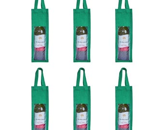 May include: Six green wine bottle tote bags with handles. Each bag features a clear window displaying a wine bottle with a label reading "Jacobs Creek". The bottles are wrapped in pink tissue paper.