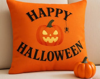 Può includere: Cuscino decorativo arancione a tema Halloween con le parole "HAPPY HALLOWEEN" in nero. Una zucca di Halloween e un ragno sono presenti sul cuscino. Una piccola zucca arancione è accanto al cuscino.