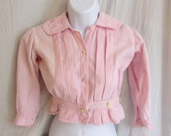 May include: A pink, long-sleeved, button-up blouse with a ruffled hem and a Peter Pan collar.