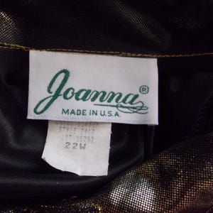 May include: A close-up of a clothing tag with the brand name "Joanna" in a cursive font, with "MADE IN U.S.A." below. The tag also includes style and size information, with a size of 22W.