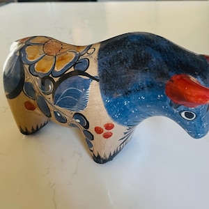 Grande statuetta messicana in ceramica brunita raffigurante un toro Tonala, nei colori blu, beige e ruggine.
