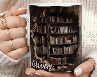 May include: White ceramic mug featuring a detailed illustration of a wooden bookshelf filled with books. The name "Olivia" is printed on the front. The mug is held by a person.