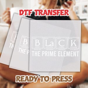 May include: Three white DTF transfer sheets. The front sheet has a grid pattern and the word "BLACK" in a periodic table style, with "THE PRIME ELEMENT" below. The top reads "DTF TRANSFER" and the bottom reads "READY TO PRESS".