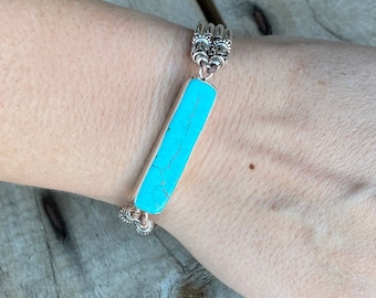 May include: A turquoise stone bracelet with silver chain links and a silver clasp.