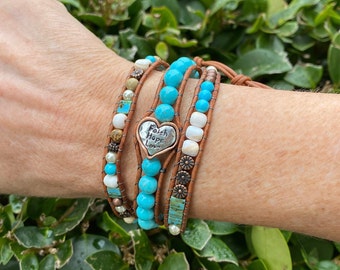 May include: A turquoise and brown leather wrap bracelet with a silver heart charm that says "Faith Hope Love".