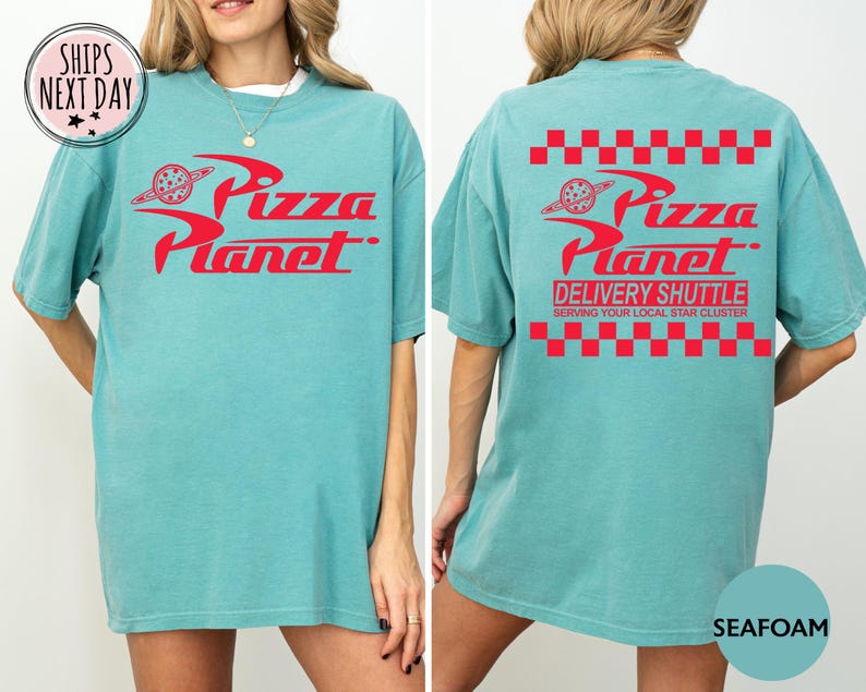 May include: Seafoam green t-shirt with the red "Pizza Planet" logo on the front and back. The back also features "Delivery Shuttle" text and a red checkered pattern. A fun, casual tee.
