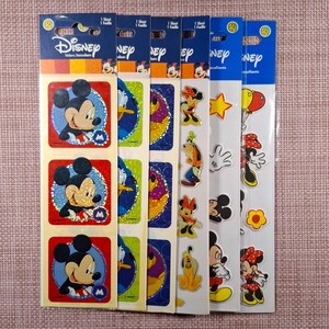 May include: Six vertical sheets of Disney stickers featuring various characters. The first three sheets display square stickers of Mickey Mouse on red, green, and blue backgrounds. The remaining sheets feature individual character stickers including Minnie Mouse, Goofy, Pluto, and Mickey Mouse with balloons.