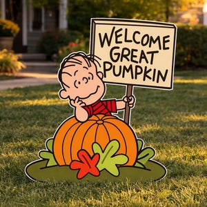 Op de afbeelding: Een tuinbord met een stripfiguur met bruin haar en een rood gestreept shirt, leunend op een grote oranje pompoen. Het figuur houdt een rechthoekig bord vast met de zwarte tekst WELCOME GREAT PUMPKIN. Onderaan bevinden zich groene en rode bladeren.