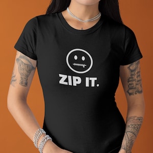 Könnte beinhalten: Ein schwarzes Kurzarm-T-Shirt mit einer weißen Grafik eines kreisförmigen Smileys, dessen Mund durch einen Reißverschluss dargestellt wird. Unter der Grafik ist der Text "ZIP IT." in einer fetten, weißen, serifenlosen Schrift gedruckt.