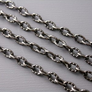 May include: Four strands of silver chain with a textured oval link design.
