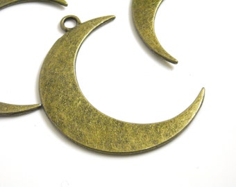 May include: Three antique gold-toned metal crescent moon charms. The charms have a slightly textured surface and are ready to be used in jewelry making.