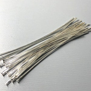 Peut inclure: Un paquet d'épingles à tête argentées, utilisées pour la fabrication de bijoux et l'artisanat.