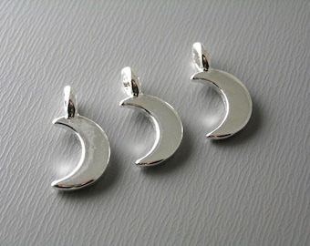 May include: Three silver crescent moon charms with a loop at the top for attaching to jewellery or other crafts.