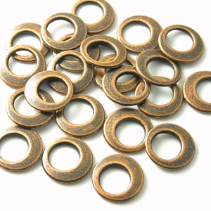 May include: A pile of antique brass metal eyelets, also known as grommets, for crafts and DIY projects.