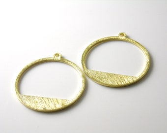 May include: Two gold-toned metal circle pendant charms with a horizontal bar cut out of the bottom half of each circle.