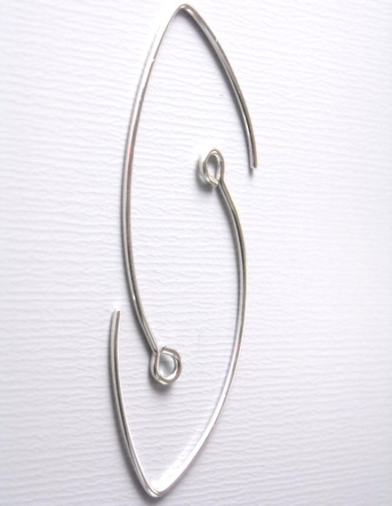 May include: Silver earring with a unique, asymmetrical design. The earring is made of a single piece of wire that is bent into a curved shape. The wire is then twisted to create a loop at the top of the earring.