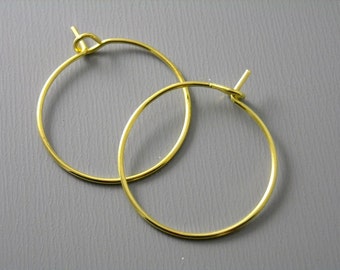 May include: A pair of gold hoop earrings with a simple, classic design.