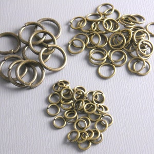 May include: A large pile of antique gold jump rings. The jump rings are small and round, perfect for jewellery making.