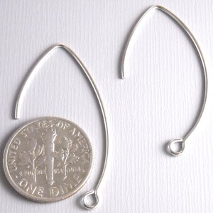 May include: Two silver earring hoops, each with a small loop at the bottom. The hoops are about the size of a US dime.
