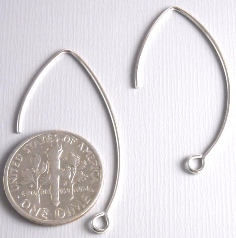 May include: Two silver earring hoops, each with a small loop at the bottom. The hoops are about the size of a US dime.