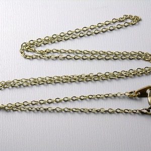 May include: A gold chain necklace with a lobster clasp closure.
