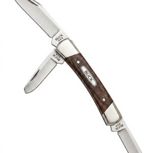 May include: A stainless steel folding pocket knife with a dark wood handle. The knife has two blades, one large and one small, and features the "BUCK USA" logo. The handle is curved and has a silver bolster.