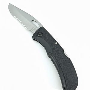 Puede incluir: Una navaja de bolsillo plegable negra con una hoja plateada parcialmente dentada. El mango tiene un agarre texturizado. La navaja tiene un pequeño agujero cerca del punto de pivote de la hoja. La hoja tiene el texto "OMEGA USA".