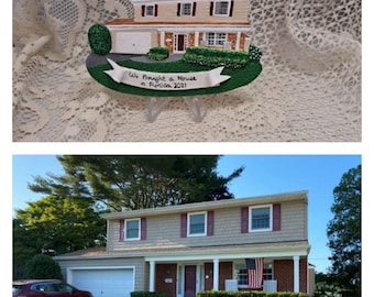 Puede incluir: Un adorno pintado a mano que representa una casa de dos pisos con techo rojo, revestimiento blanco y césped verde. El adorno tiene una pancarta blanca que dice "We bought a house in Florida 2021".