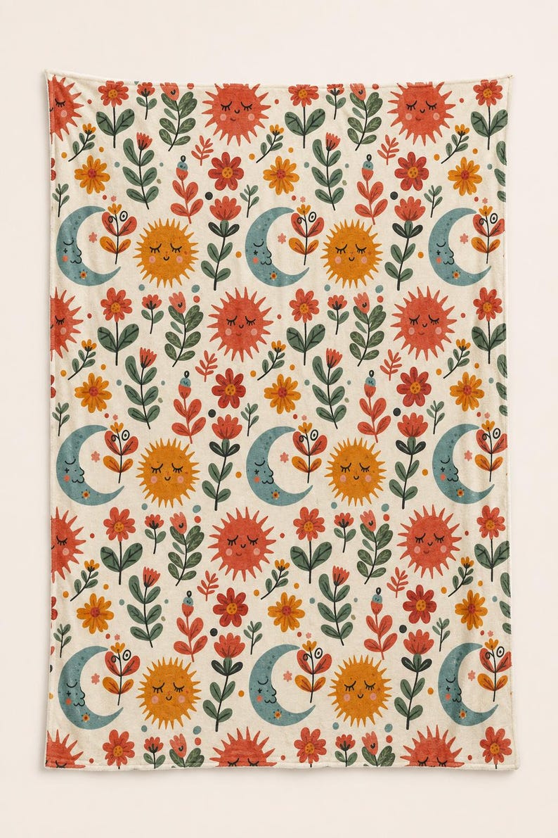 May include: A rectangular blanket featuring a repeating pattern of smiling suns in orange and red, crescent moons in muted blue, and various stylized flowers in shades of red, orange, and green against a cream-colored background.