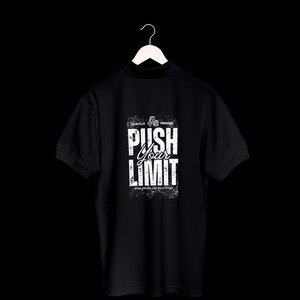 Puede incluir: Polo negro con texto blanco "PUSH YOUR LIMIT" en la espalda. La camisa est&aacute; colgada de una percha blanca sobre un fondo negro. El texto tiene una apariencia desgastada y texturizada.