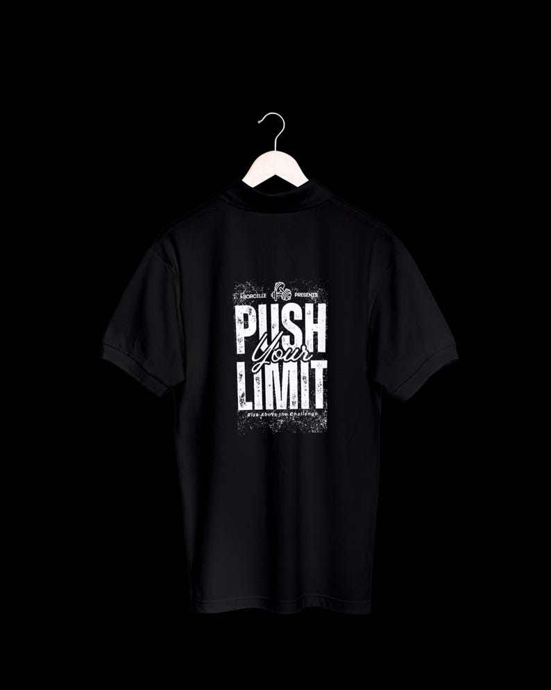 Puede incluir: Polo negro con texto blanco "PUSH YOUR LIMIT" en la espalda. La camisa est&aacute; colgada de una percha blanca sobre un fondo negro. El texto tiene una apariencia desgastada y texturizada.