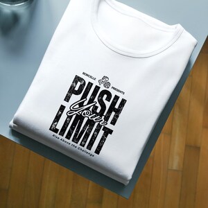 Puede incluir: Camiseta blanca con cuello redondo, con el texto "PUSH YOUR LIMIT" en negro, con una fuente audaz y desgastada. La camiseta tambi&eacute;n incluye el texto "Rise Above the Challenge" y un peque&ntilde;o gr&aacute;fico de mancuernas.