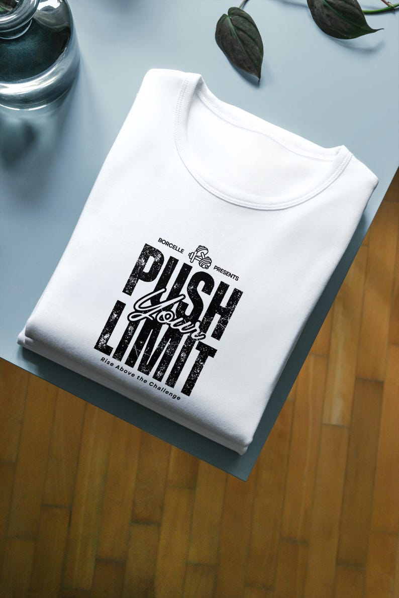 Puede incluir: Camiseta blanca con cuello redondo, con el texto "PUSH YOUR LIMIT" en negro, con una fuente audaz y desgastada. La camiseta tambi&eacute;n incluye el texto "Rise Above the Challenge" y un peque&ntilde;o gr&aacute;fico de mancuernas.