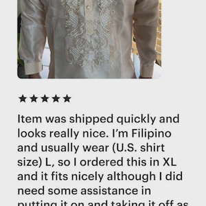 May include: A long-sleeved, cream-colored barong tagalog shirt featuring a button-down placket and intricate white embroidery along the front panel and cuffs. The garment is constructed from a semi-sheer, non-stretch fabric.