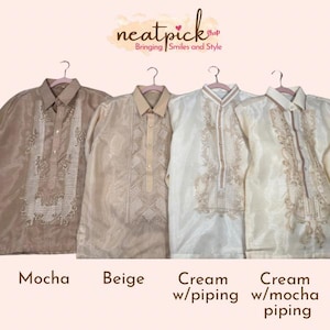 May include: Four long-sleeved barong shirts in mocha, beige, cream, and cream with mocha piping. Each shirt features a button-down collar, a central vertical panel with intricate embroidery, and a sheer, lightweight fabric construction.