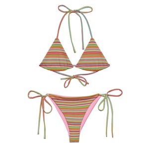 May include: A vibrant two-piece bikini set with a striped pattern. The top is a triangle style with halter ties, and the bottom is a tie-side design. The bikini features a mix of pink, orange, green, and blue stripes.