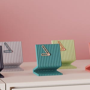 Peut inclure: Plusieurs horloges modernes et colorées, dans des tons de noir, gris, turquoise, vert et corail. Chaque horloge présente un design minimaliste avec une texture côtelée et une aiguille contrastante.