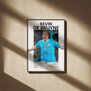 Puede incluir: Póster enmarcado con Kevin De Bruyne con una camiseta de fútbol azul claro con el logo de Etihad Airways. El póster incluye el nombre del jugador, su firma y estadísticas de carrera. El fondo es beige neutro.