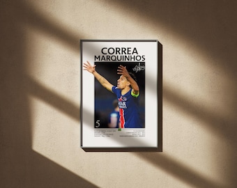 May include: Framed poster featuring a soccer player in a blue jersey with red and white accents, arms raised in celebration. The poster includes the player's name, "CORREA MARQUINHOS," and other details. The background is a neutral color.