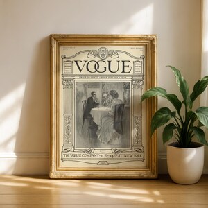 Op de afbeelding: Een vintage Vogue tijdschriftomslag in een goudkleurige, sierlijke lijst. De omslag bevat een zwart-witillustratie van twee personen aan een tafel, met de tekst VOGUE, THE VOGUE COMPANY, 11 E 24TH ST NEW YORK en andere publicatiegegevens.