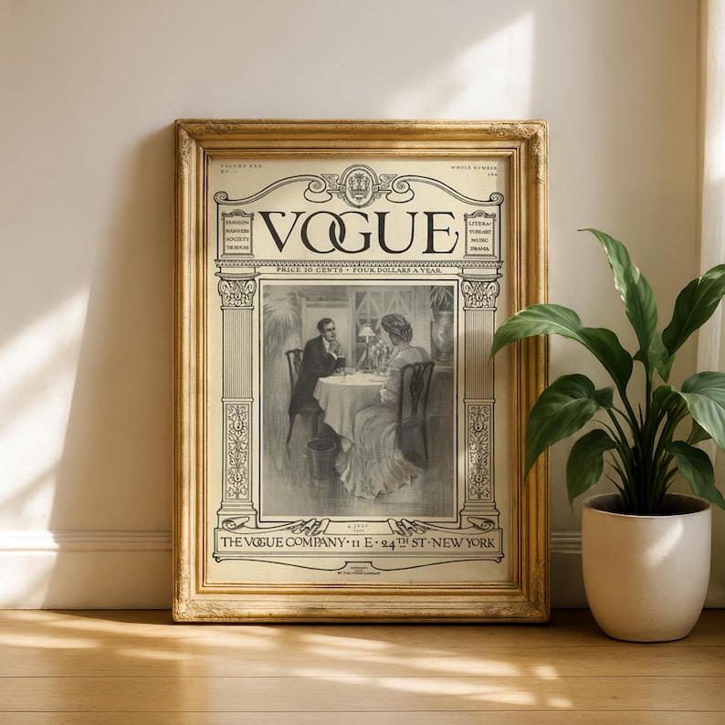 Op de afbeelding: Een vintage Vogue tijdschriftomslag in een goudkleurige, sierlijke lijst. De omslag bevat een zwart-witillustratie van twee personen aan een tafel, met de tekst VOGUE, THE VOGUE COMPANY, 11 E 24TH ST NEW YORK en andere publicatiegegevens.