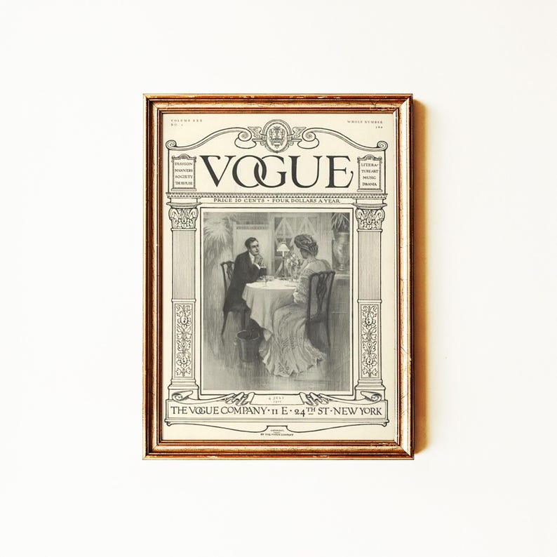 May include: A framed vintage Vogue magazine cover print featuring a black and white illustration of two people seated at a table. The text reads VOGUE, THE VOGUE COMPANY 11 E 24TH ST NEW YORK, and includes volume and price details in a decorative border.