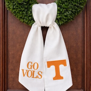 May include: A white ceramic mug with a black handle and the text "But First, Coffee" in a black, handwritten-style font. The mug is on a white surface.