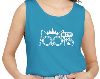 May include: A bright blue sleeveless tank top featuring a white graphic print of a stylized cat wearing round glasses and a crown, with a speech bubble containing the text HI ZEV! and a small paw print icon positioned to the right side.