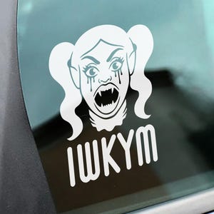 May include: White vinyl sticker featuring a stylized illustration of a crying vampire woman with fangs and the text "IWKYM". The woman has long wavy hair in pigtails and is crying tears. The sticker is likely for a car window or other smooth surface.