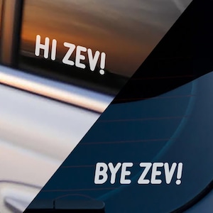 May include: White vinyl car window decals with the phrases "HI ZEV!" and "BYE ZEV!" in a bold, sans-serif font. The decals are applied to the rear windows of a vehicle, with a partial view of the car's exterior.