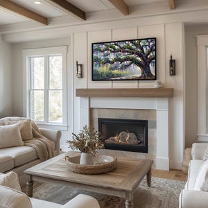 May include: A living room with a fireplace, a large framed painting of a tree, and a wooden coffee table. The fireplace has a stone surround and a black firebox. Two sconces flank the painting. The room is decorated in neutral tones.