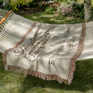 Close-up of custom woven blanket with names and EST year in a cozy minimal bedroom