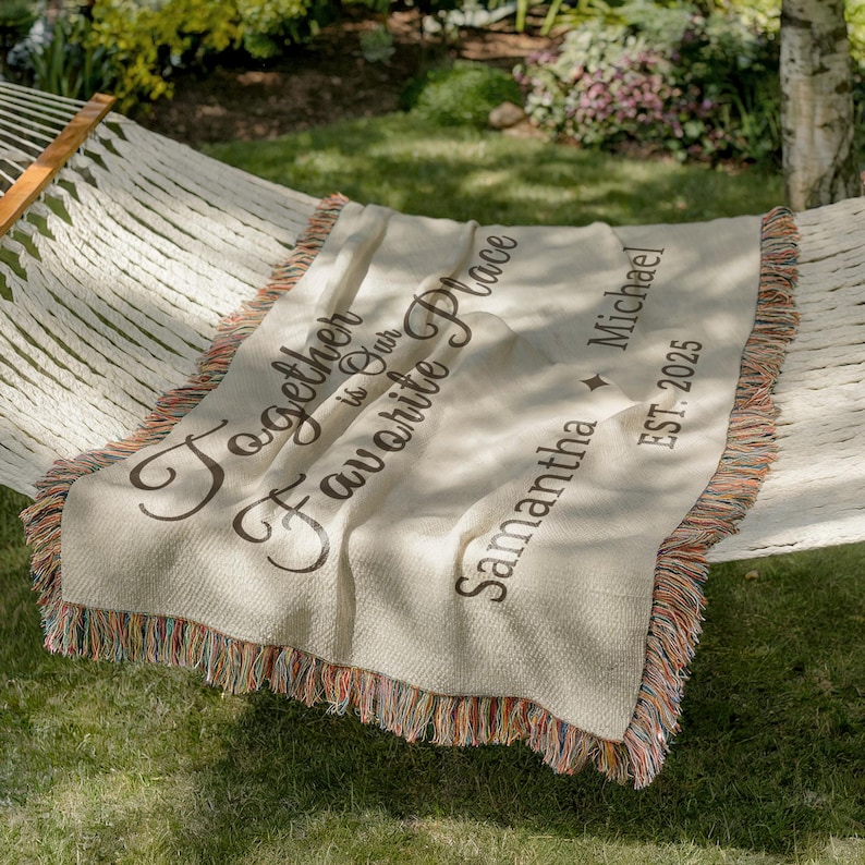 Close-up of custom woven blanket with names and EST year in a cozy minimal bedroom